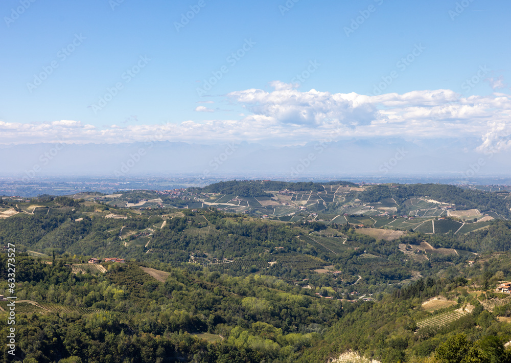 View of the Langhe-Roero hills and vineyards in Piedmont with the Alps in the background. Italy