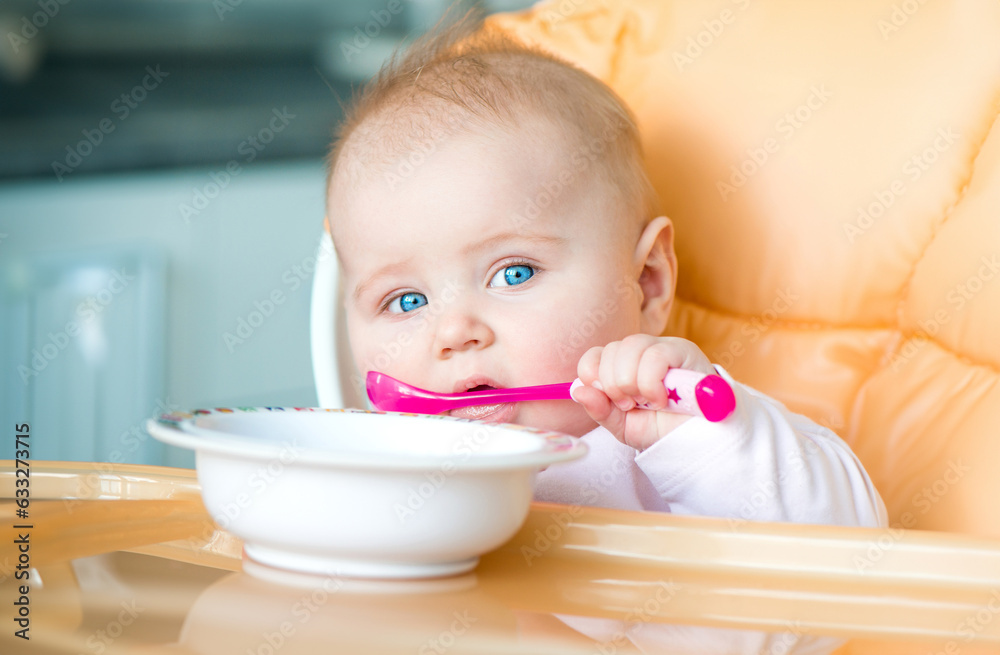 smiley baby girl is holding a spoon in her mouth and going to eat smiley baby girl is holding a spoon in her mouth and going to eat