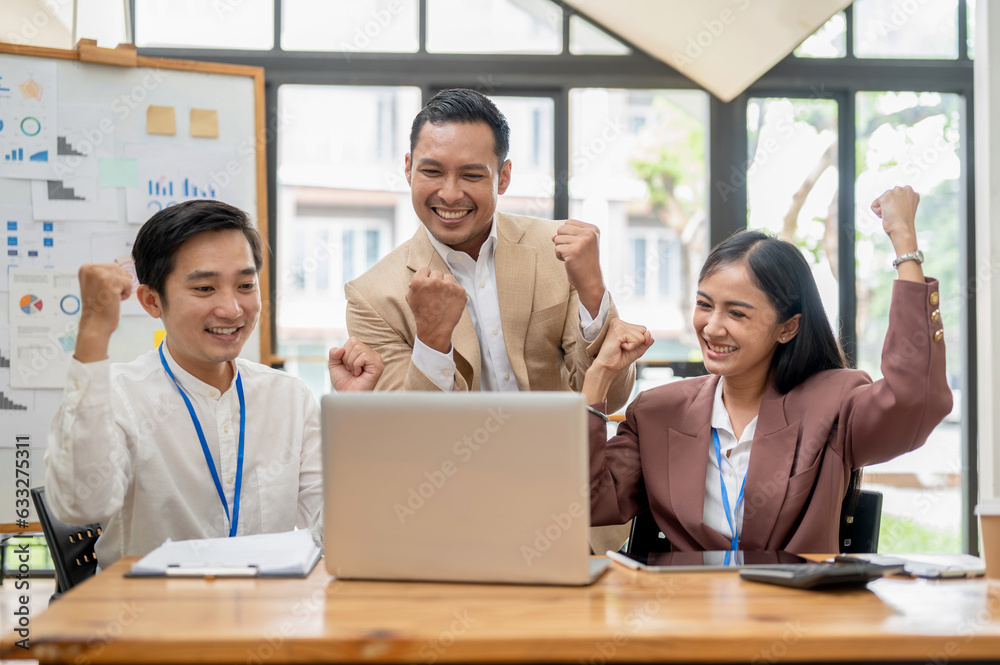 A group of cheerful Asian businesspeople are rejoicing in their project success together. A group of cheerful Asian businesspeople are rejoicing in their project success together.