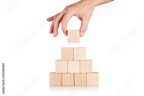 wooden cubes in the form of a pyramid with a hand on an isolate white background