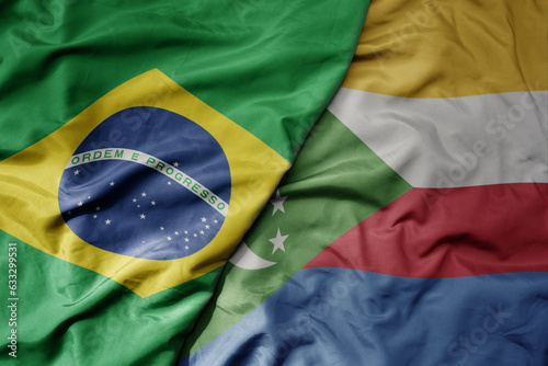 big waving realistic national colorful flag of brazil and national flag of comoros .