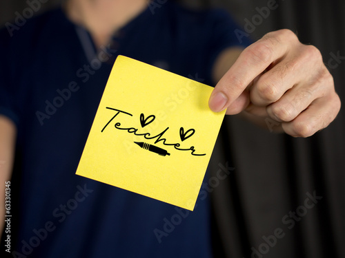 Teacher hand holding a yellow stick note, a back-to-school concept