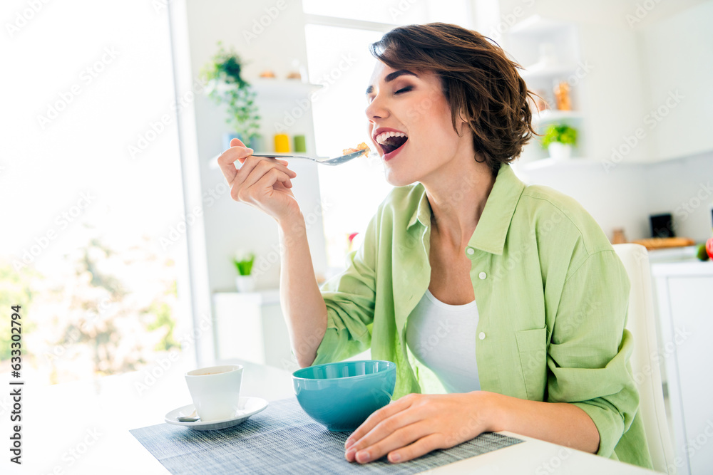 Photo of dreamy positive lady dressed green shirt eating healthy muesli closed eyes indoors house kitchen