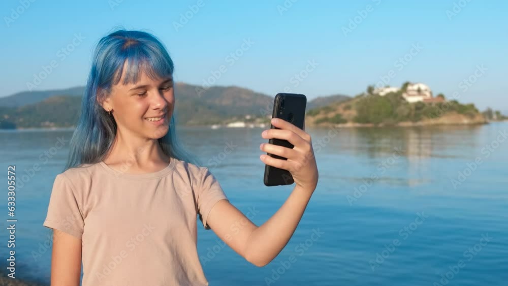 Stylish girl speak on smartphone in sea sun. A stylish teen speak with somebody on phone during promenade in the nature park in summer. Stylish girl speak on smartphone in sea sun. A stylish teen speak with somebody on phone during promenade in the nature park in summer.