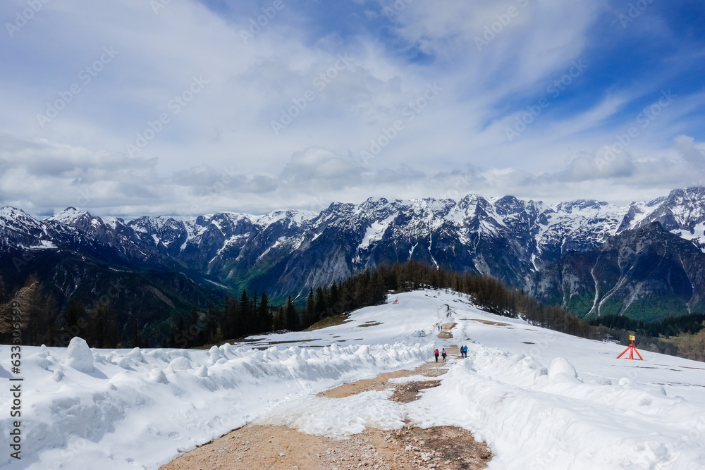 path with snow and a amazing view to a mountain range in upper austria