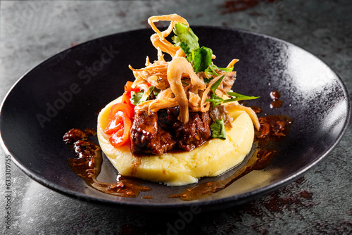 Stewed veal cheeks with mashed potatoes on plate