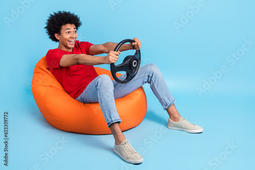 Fototapete Full length photo of funny person wear red t-shirt sit on pouf hold steering whe