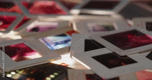 Photographic slides in plastic frames thrown on a light table. Background shot. Camera glide movement photo