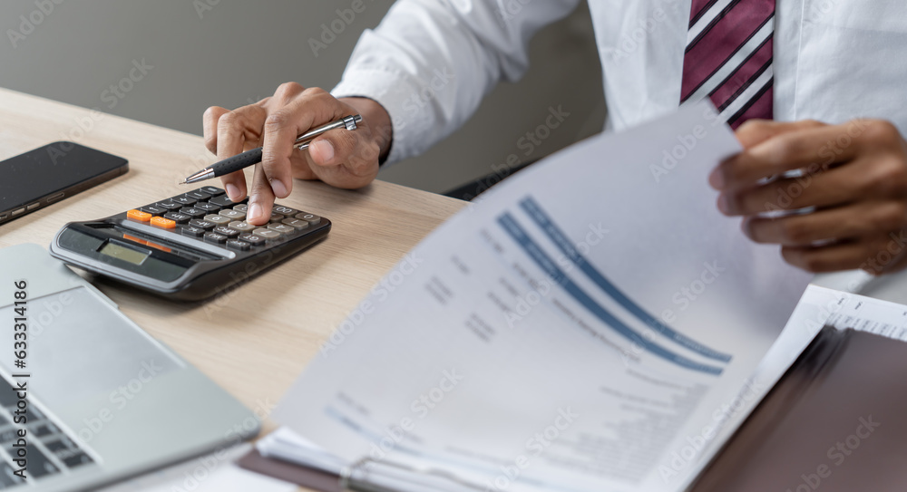 Fototapeta premium Businessman Accountant analyzing investment charts Invoice and pressing calculator buttons over documents. Accounting Bookkeeper Clerk&nbsp;Bank Advisor And Auditor Concept.