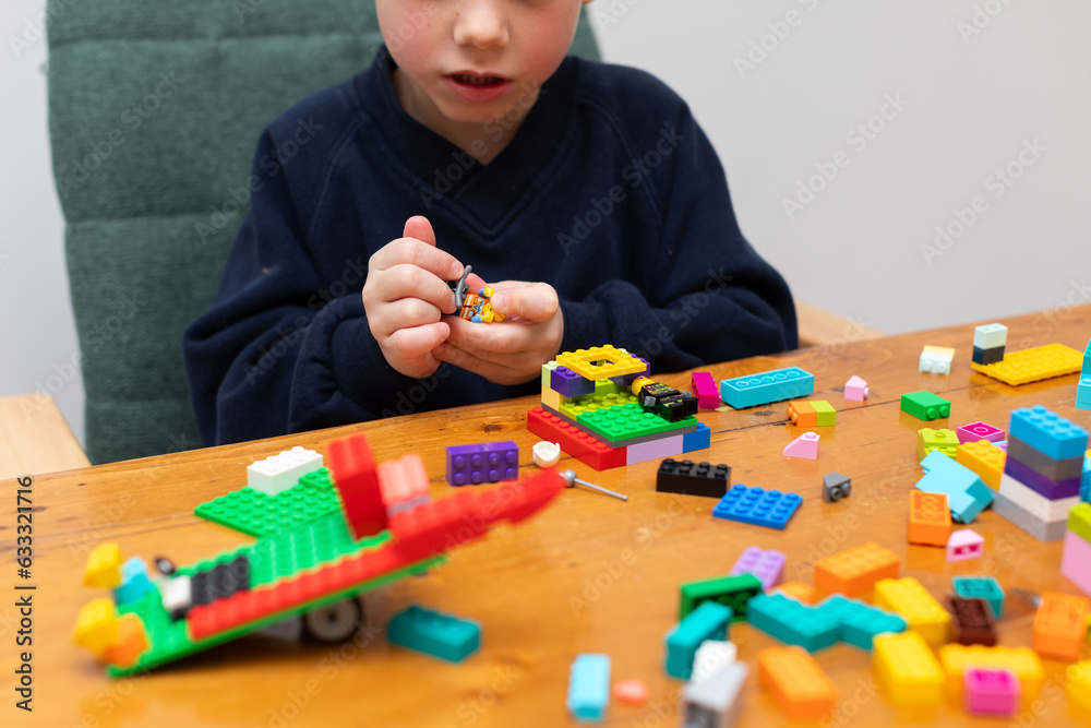Fototapeta premium A young boy building colored brick toys.