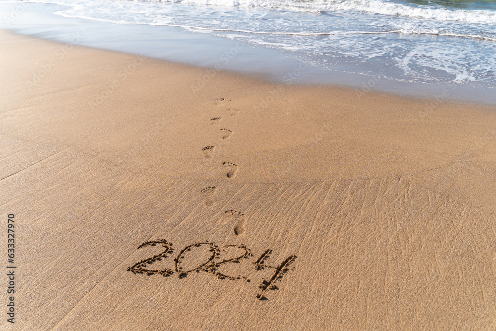 2024 hand written in sand on a beautiful beach
