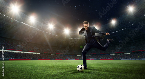 Emotional businessman hitting football ball on 3d arena with flashlights. Earning money during match. Concept of sport, fan, betting and finances, gambling, bookmaker