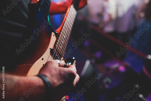 Fotografia Concert view of an electric guitar player with vocalist and rock band performing