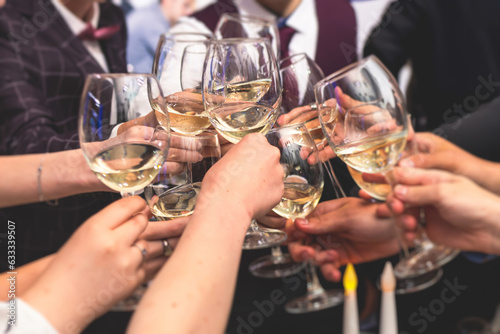 Foto Group of guests celebrate and raise glasses, cheering with alcohol glasses with