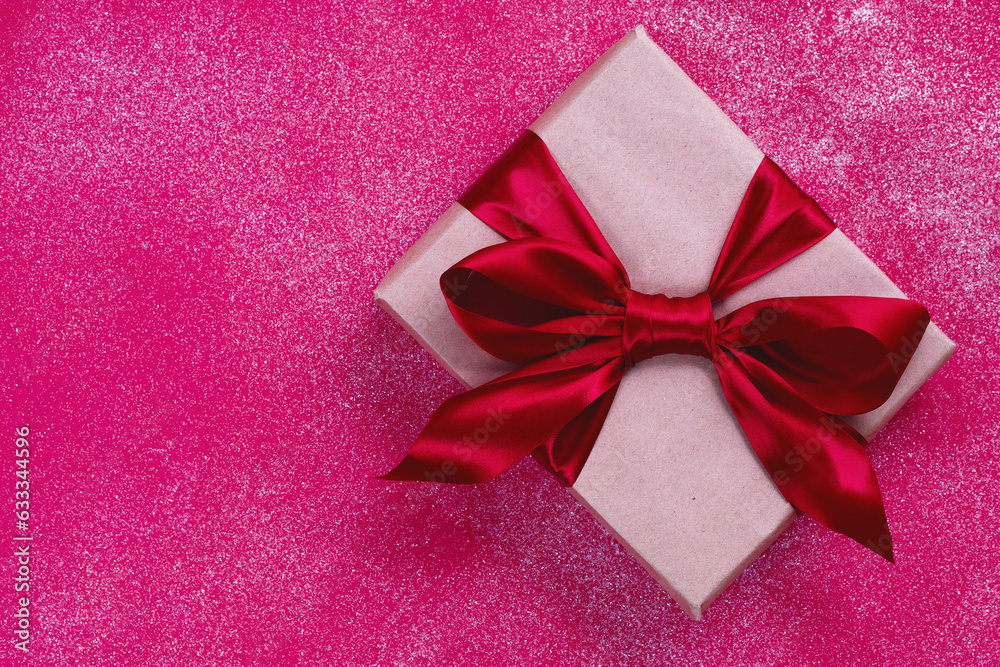 Rectangular brown box with a gift inside. Surprise for a beloved woman tied with a red bow. Rectangular brown box with a gift inside. Surprise for a beloved woman tied with a red bow.