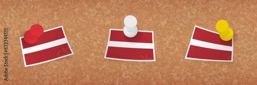 Latvia flag pinned in cork board, three versions of Latvia flag.