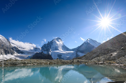 Dent Blanche with sunstar mirroring in an glacier lake © schame87