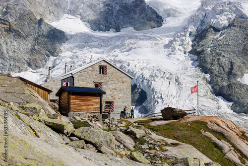 Cabane du Mountet in front of Glacier with Swiss Flag photo