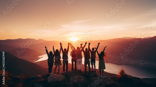 Group of people having fun in success victory and happy pose with raised arms on mountain top against sunset lakes and mountains. AI generative.