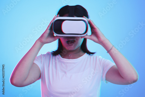Woman, VR technology and surprise in studio for user experience, digital world and future multimedia game on blue background. Virtual reality glasses, metaverse and wow for innovation of UX gaming