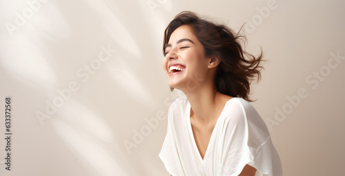 Smiling woman standing in frot of pastel colored wall photo