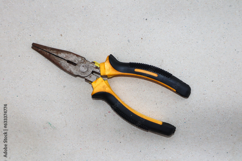 Obraz premium Yellow pliers and black pliers on a white background,close up photo.