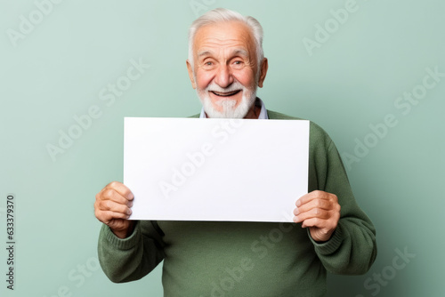 Happy old man holding blank white banner sign, isolated studio portrait.