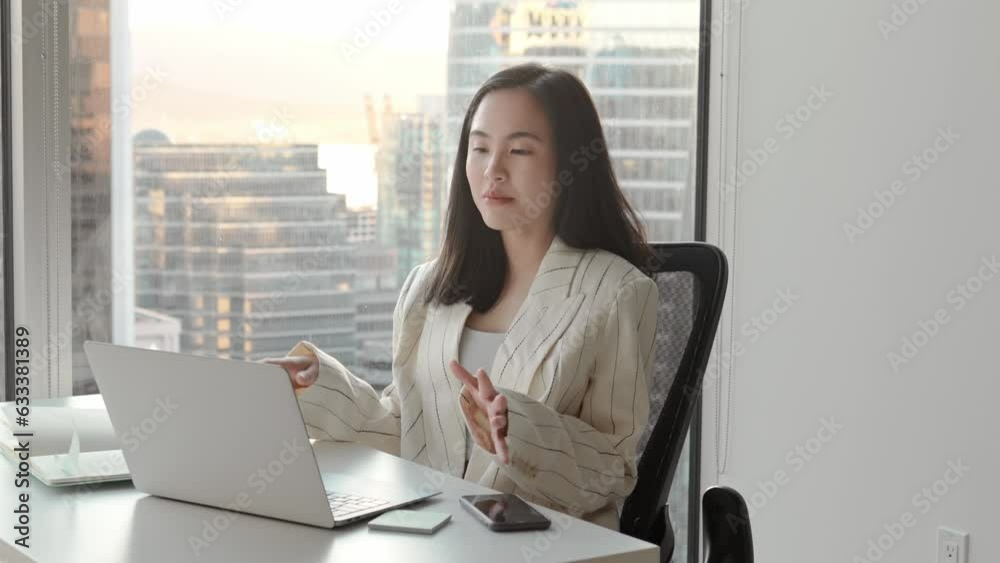 Young Asian business woman communicating by video conference call meeting. Female executive leader or hr manager talking having remote job interview working on laptop in modern office. Young Asian business woman communicating by video conference call meeting. Female executive leader or hr manager talking having remote job interview working on laptop in modern office.