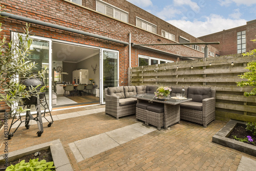 an outdoor living area with patio furniture and brick pavers on either side of the home's front door