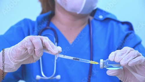Medicine doctor is filling the medical syringe. Physician is preparing medicine solution for her patient in emergency room at the hospital.