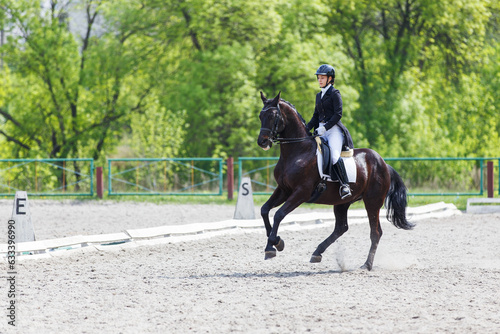Young horse rider girl on her advanced dressage test in equestrian competition