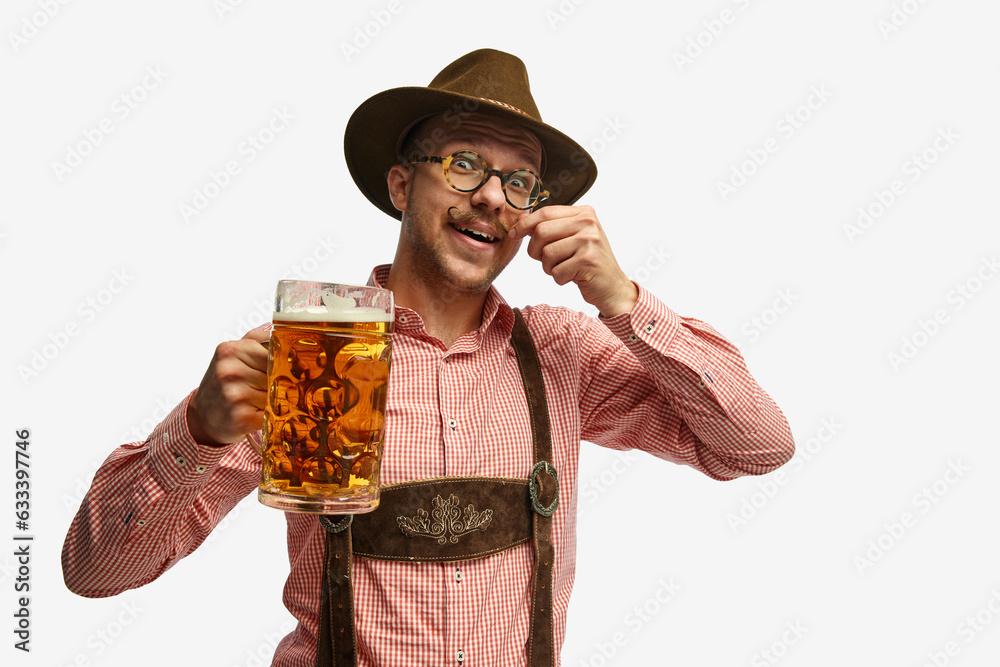 Portrait of attractive young man in hat, wearing folk Bavarian clothes, holding beer mug isolated white background. Concept of Oktoberfest - obrazy, fototapety, plakaty 