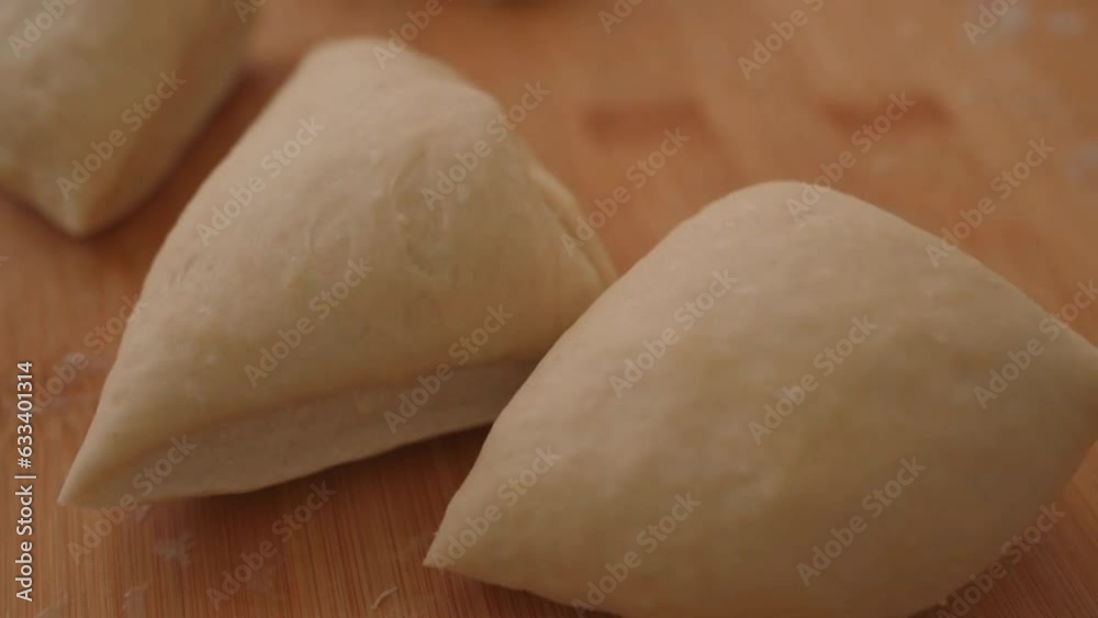Woman cutting bread dough with a skepper on a wooden table Woman cutting bread dough with a skepper on a wooden table