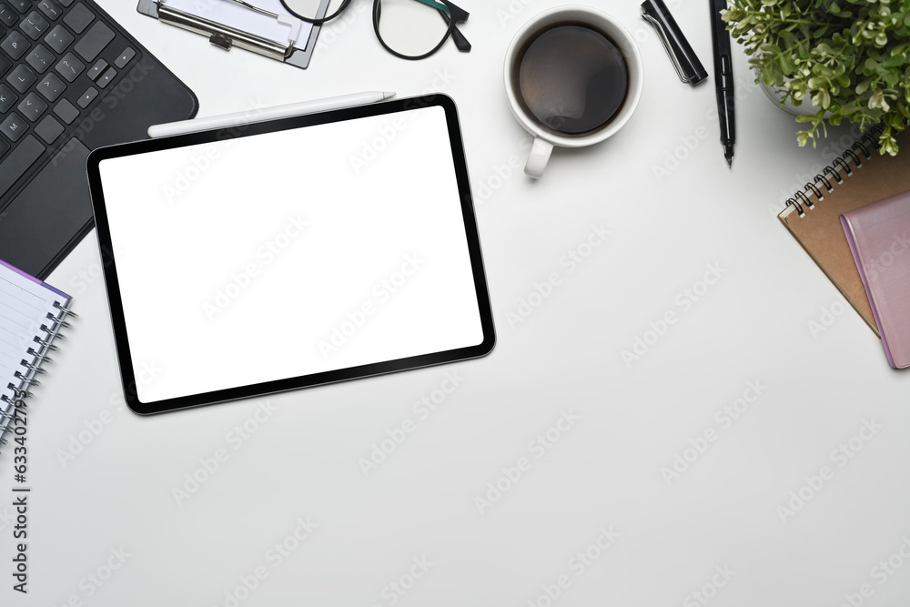 Digital tablet empty screen on office white table with overhead shot.