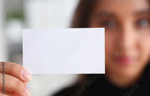 portrait of young beautiful brunette chinese businesswoman work in office show cutaway business card