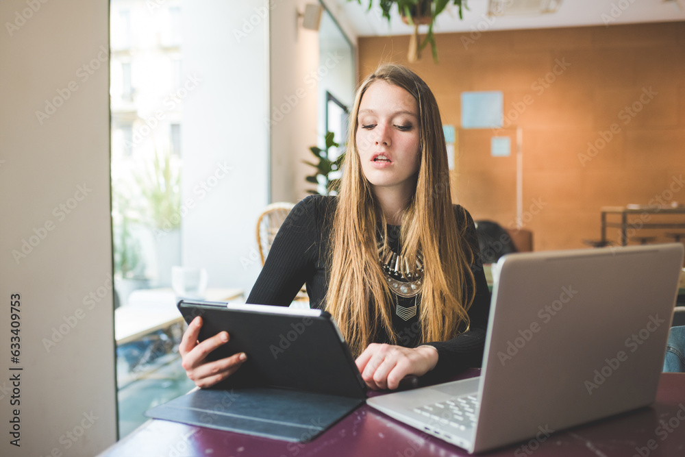 Young businesswoman young multitasking using computer and tablet Young businesswoman young multitasking using computer and tablet