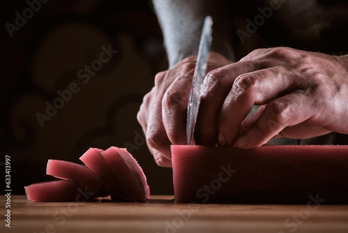 Bilde på lerret Male hands slicing fresh bluefin tuna loin