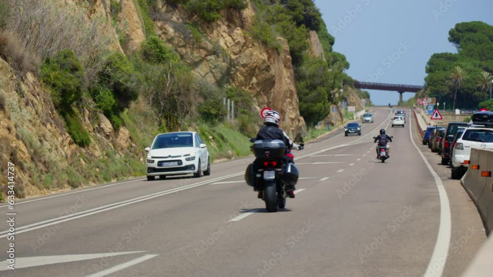 A motorcyclist and a car are driving along the road A motorcyclist and a car are driving along the road