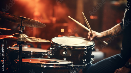 young man playing drums in dark club