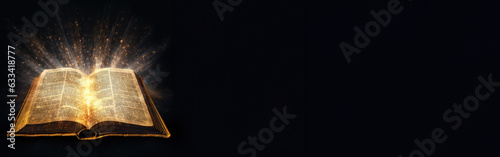 Shining Holy Bible on black background banner, Holy bible with magic glows In the dark background, copy space for text photo
