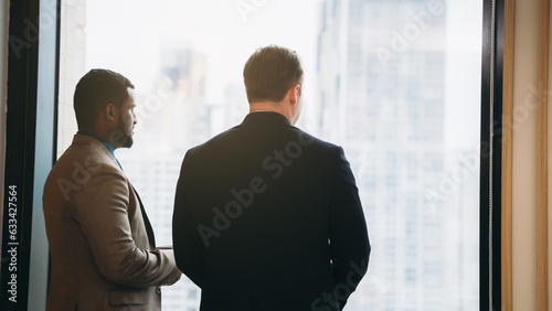 In the workplace, two coworkers are talking about the project. Business people walking in the passageways of an office building and talking.