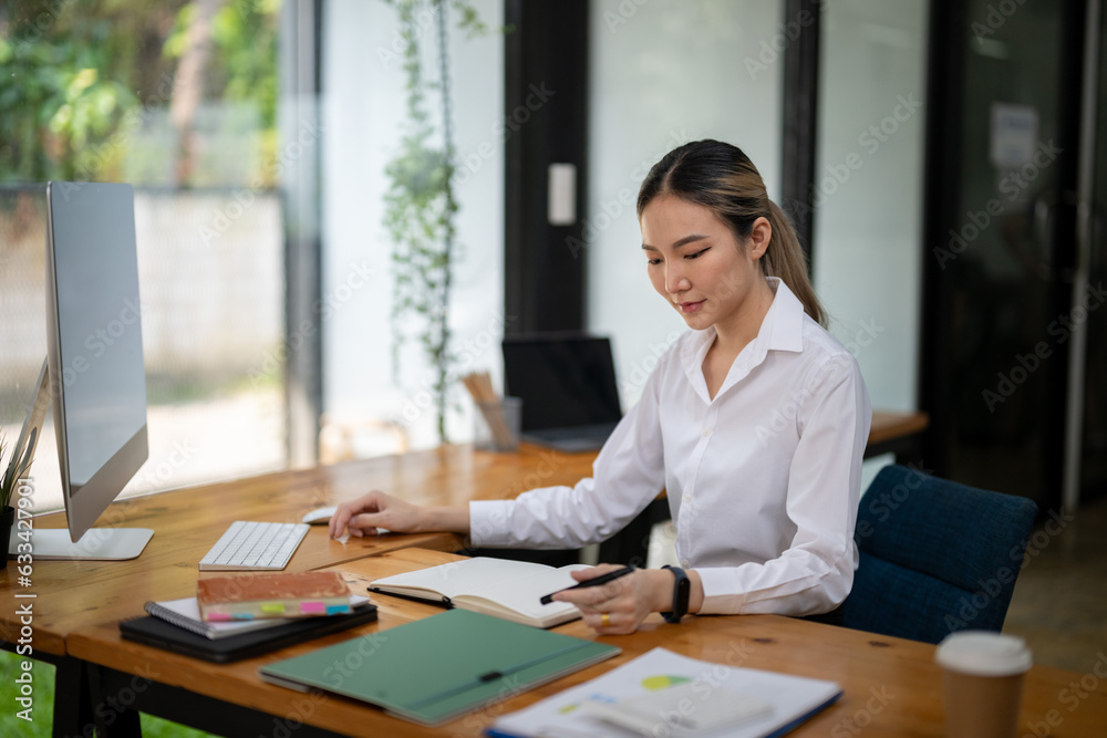 Asian businesswoman thinking about a new project and taking note of new ideas. Asian businesswoman thinking about a new project and taking note of new ideas.