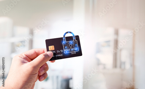 Close up of man hand holding credit or debit card with padlock, protection of financial transactions, copy space, Financial security technology concept.