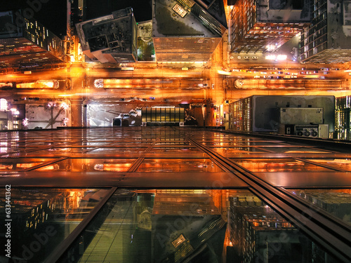 An breathtaking view of a city at night (Chicago, Illinois). The city is bathed in lights, and the streets are teeming with activity and full of energy. The traffic lights create a dazzling display.