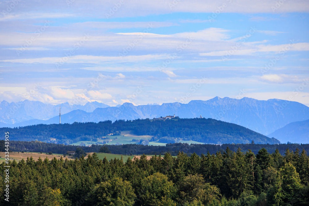 Alpine view over meadows and field paths towards the Alps near Reichling in Bavaria on a summer day with blue sky and light clouds