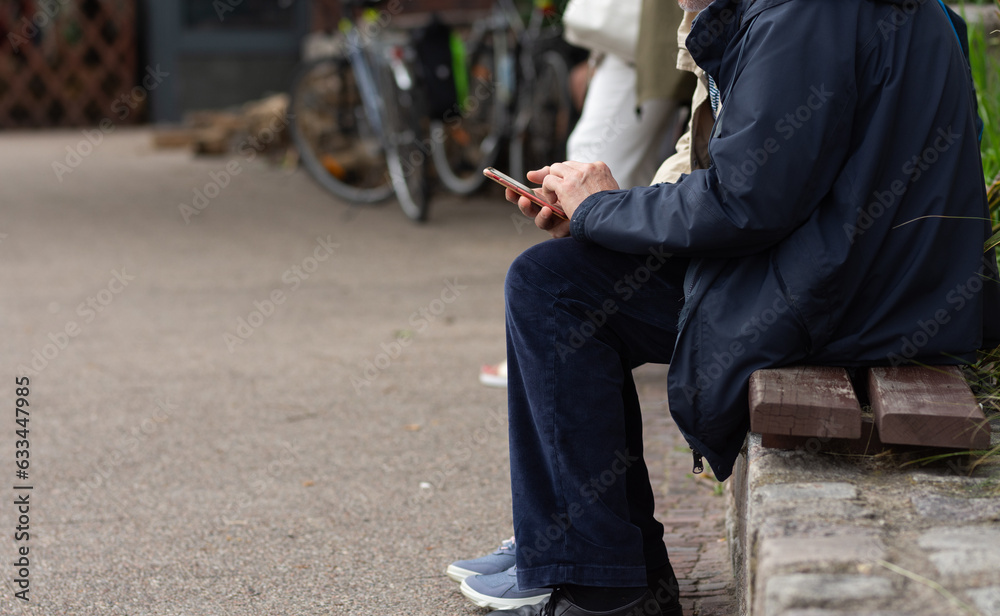 Older person sitting and browsing phone