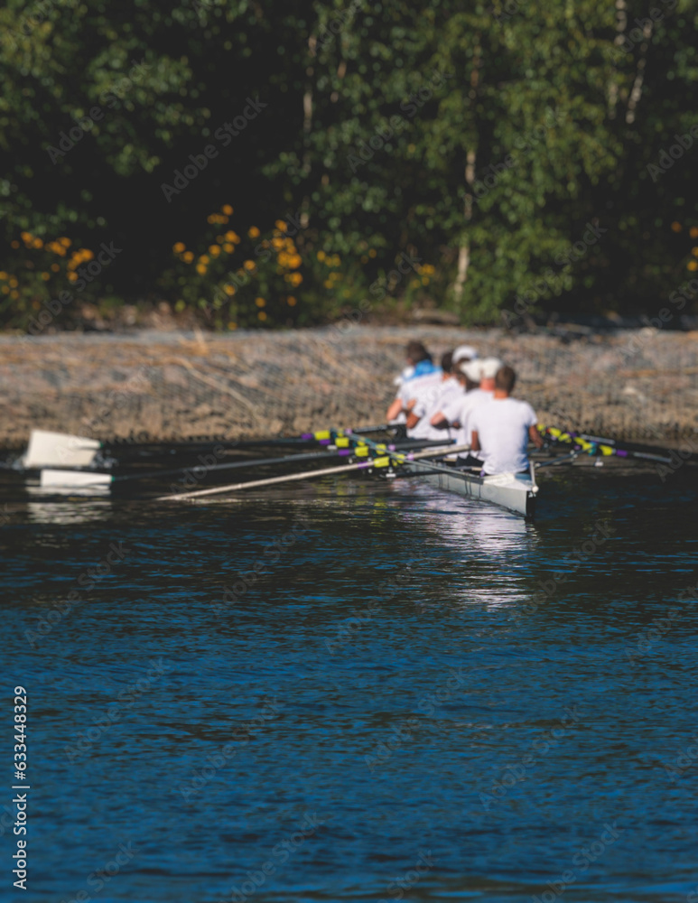 Group of rowing team athletes sculling during competition, kayak boats race in a rowing canal, regatta in a summer sunny day, canoeing water sports team training in a river