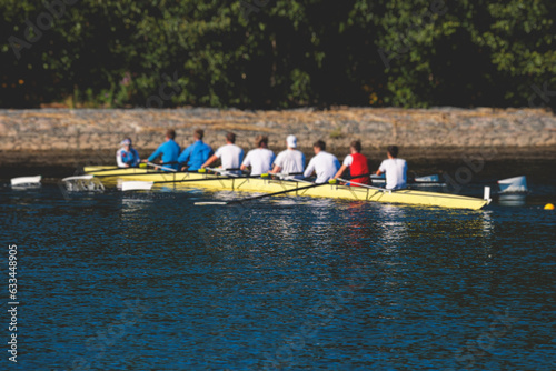 Group of rowing team athletes sculling during competition, kayak boats race in a rowing canal, regatta in a summer sunny day, canoeing water sports team training in a river photo