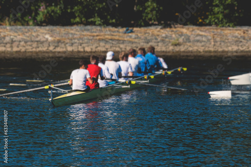 Group of rowing team athletes sculling during competition, kayak boats race in a rowing canal, regatta in a summer sunny day, canoeing water sports team training in a river