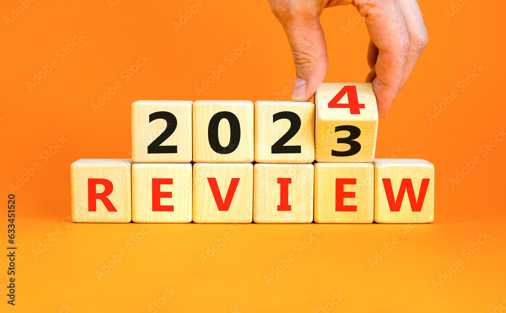 2024 review new year symbol. Businessman turns a wooden cube and